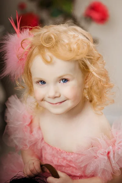 Dziecko w różowej sukience na koniu zabawka — Zdjęcie stockowe
