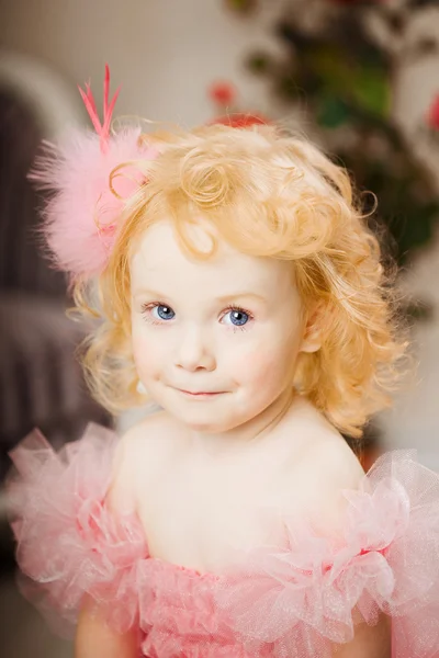 Kind im rosa Kleid auf einem Spielzeugpferd — Stockfoto