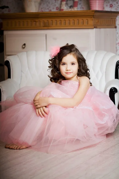 Meisje in de kinderkamer in roze jurk — Stockfoto