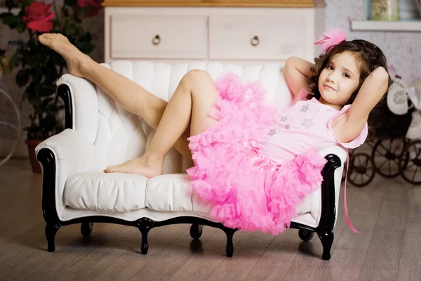 Meisje in de kinderkamer in roze jurk — Stockfoto