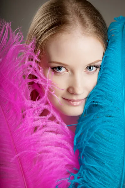 Krásná dívka s barevné peří — Stock fotografie
