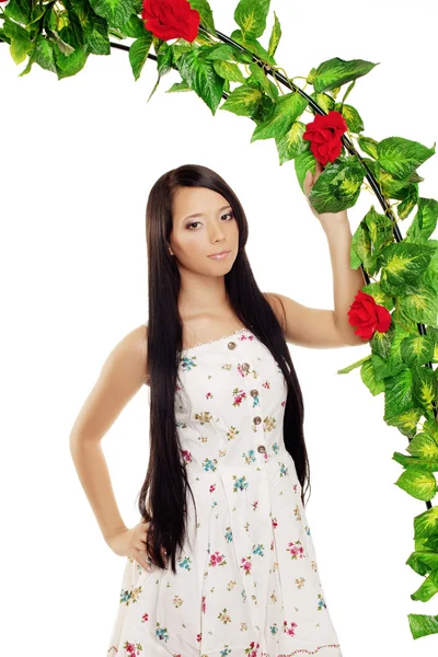 Menina jubilosa perto do arco entrelaçado por rosas — Fotografia de Stock