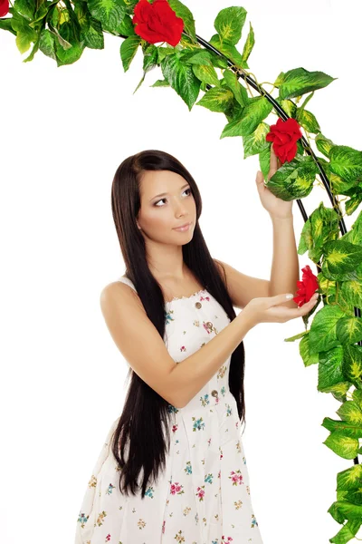 Девушка рядом с аркой, переплетенная розами — стоковое фото