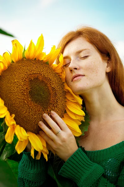 Roodharige vrouw met zonnebloemen — Stockfoto
