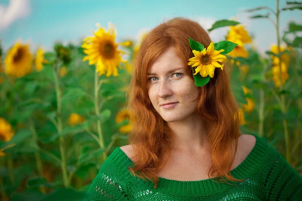 Rödhårig kvinna med solrosor — Stockfoto