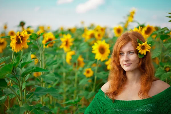 Rothaarige Frau mit Sonnenblumen — Stockfoto