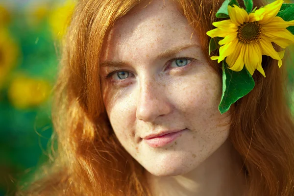 Rothaarige Frau mit Sonnenblumen — Stockfoto