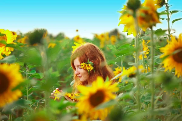 Rödhårig kvinna med solrosor — Stockfoto
