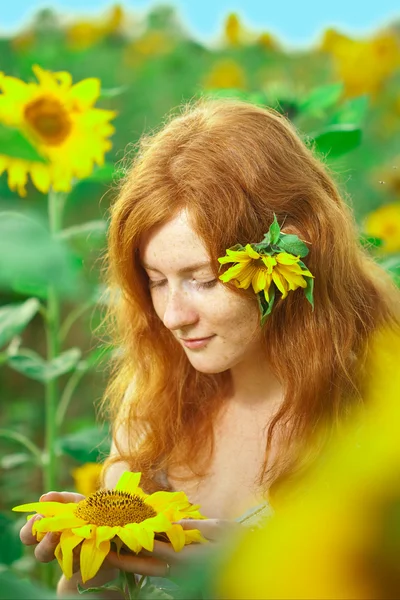 Red-haired woman with sunflowers — Stock Photo, Image