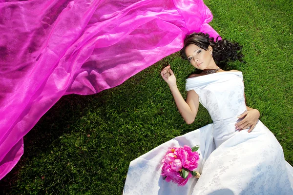 Noiva de beleza com um longo véu roxo — Fotografia de Stock