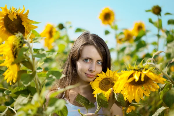 Γυναίκα με μπλε μάτια με ηλιοτρόπια — Φωτογραφία Αρχείου