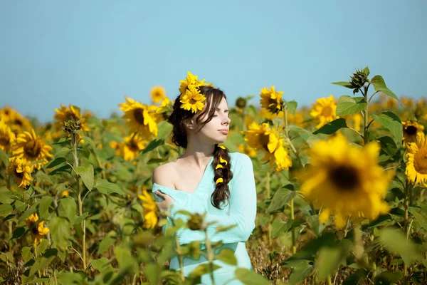 Frau mit blauen Augen mit Sonnenblumen — Stockfoto