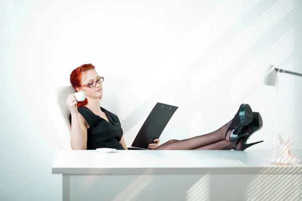 Redheaded woman in the workplace — Stock Photo, Image