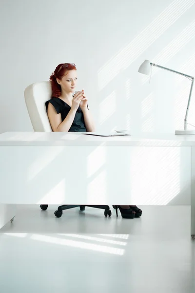 Donna dai capelli rossi sul posto di lavoro — Foto Stock