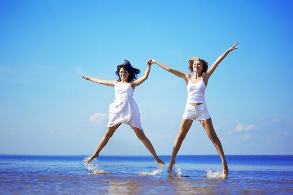 Schöne Mädchen, die am Strand springen — Stockfoto