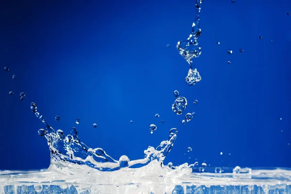 Splash op een blauwe achtergrond — Stockfoto