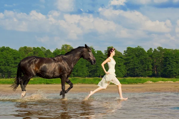 Frau auf einem Pferd am Meer Stockbild