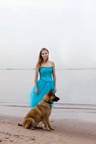 Žena a pes na pláži — Stock fotografie