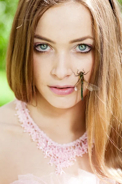 Femme avec une libellule sur le visage — Photo
