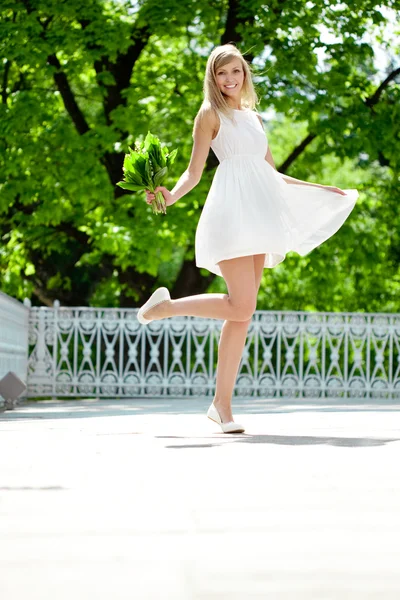 Portrait of young smiling woman in jump, outdoors — Stock Photo, Image