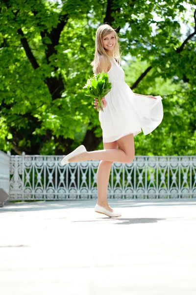 Ritratto di giovane donna sorridente in salto, all'aperto — Foto Stock