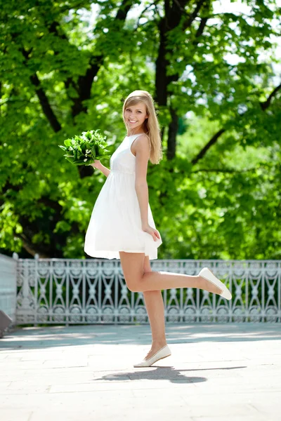 Retrato de jovem mulher sorridente no salto, ao ar livre — Fotografia de Stock