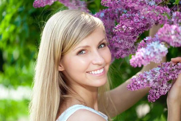 Усміхнена красива жінка з фіолетовими квітами — стокове фото