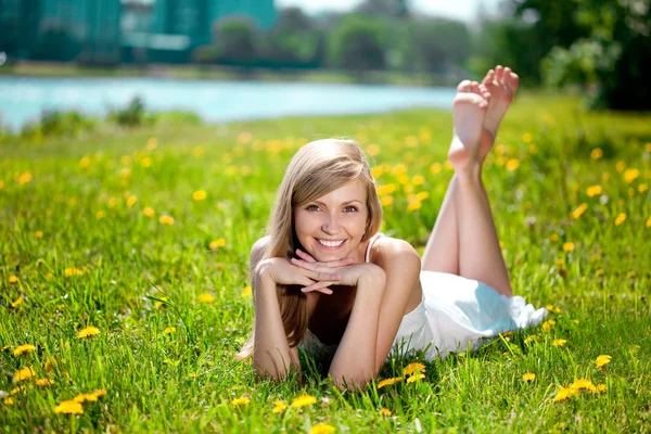 Bela mulher sorridente deitada na grama — Fotografia de Stock