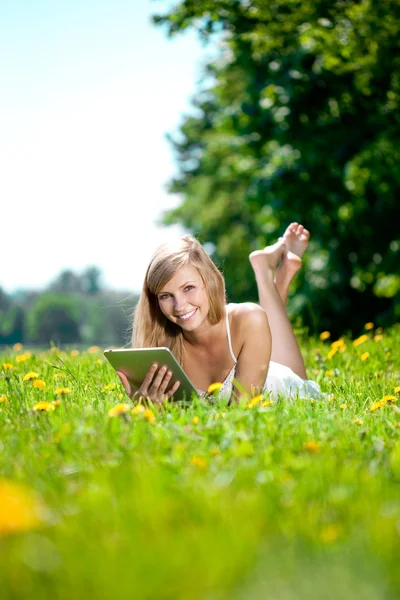 Mooie lachende vrouw met tablet pc, buitenshuis — Stockfoto