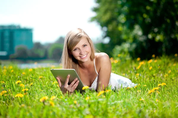 Piękna kobieta uśmiechający się z komputera typu tablet, na zewnątrz — Zdjęcie stockowe