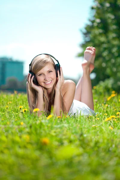 Χαμογελαστή γυναίκα γυναίκα, να ακούτε μουσική στα ακουστικά σε εξωτερικούς χώρους — Φωτογραφία Αρχείου