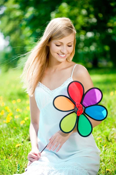 Femme souriante avec une fleur arc-en-ciel à l'extérieur — Photo