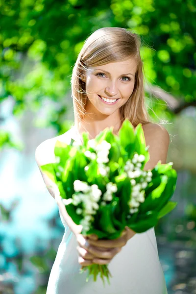 Jovem mulher sorrindo e dar um buquê de flores — Fotografia de Stock