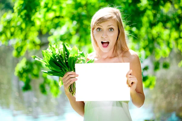 Jonge mooie lachende vrouw met lege poster buitenshuis — Stockfoto
