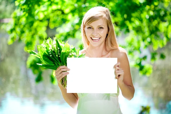 Gelukkig mooie lachende vrouw met lege poster buitenshuis — Stockfoto