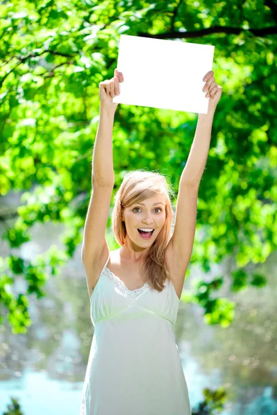 Feliz hermosa mujer sonriente con cartel en blanco al aire libre — Foto de Stock