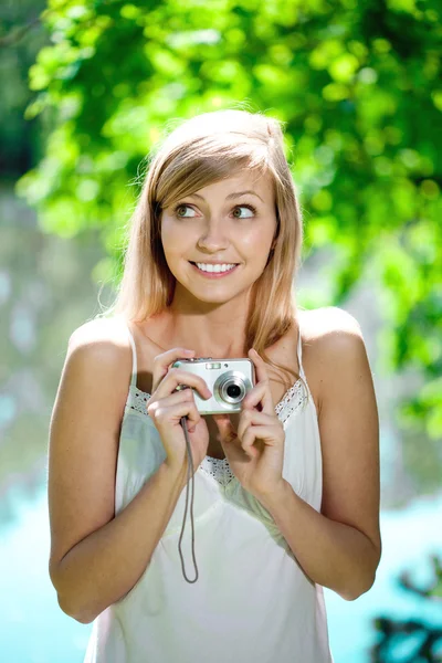 Όμορφη χαμογελαστό γυναίκα με μια φωτογραφική μηχανή, σε εξωτερικούς χώρους — Φωτογραφία Αρχείου