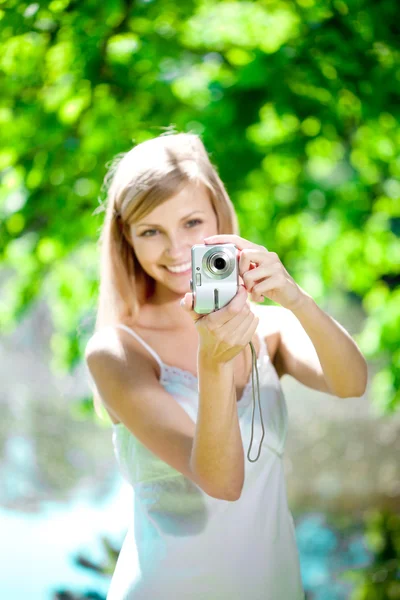 Улыбающаяся женщина с фотоаппаратом, снаружи — стоковое фото
