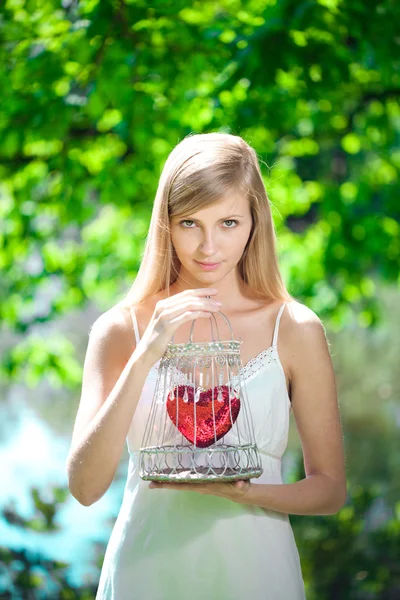 Ledsen kvinna med ett hjärta i en bur — Stockfoto