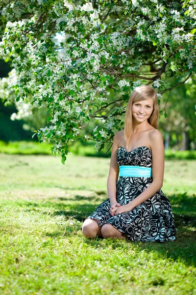 Lachende mooie vrouw en bloeiende boom — Stockfoto