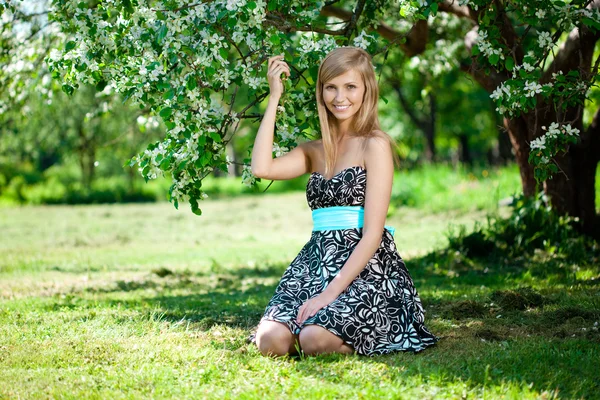 Sorridente bella donna e albero fiorito — Foto Stock