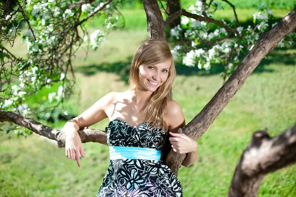 Usmívající se krásná žena a kvetoucí strom — Stock fotografie