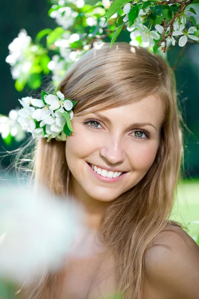Χαμογελώντας όμορφη γυναίκα με λουλούδια — Φωτογραφία Αρχείου