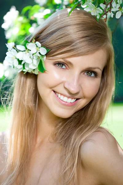 Lächelnde schöne Frau mit Blumen — Stockfoto