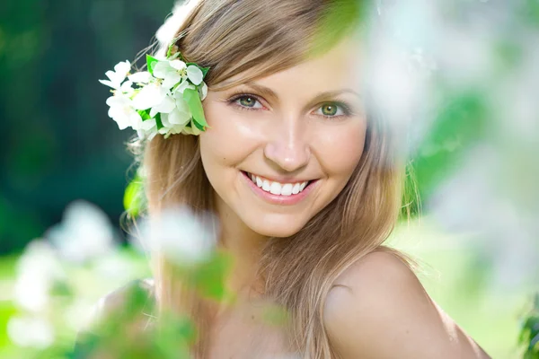 Lachende mooie vrouw met bloemen — Stockfoto