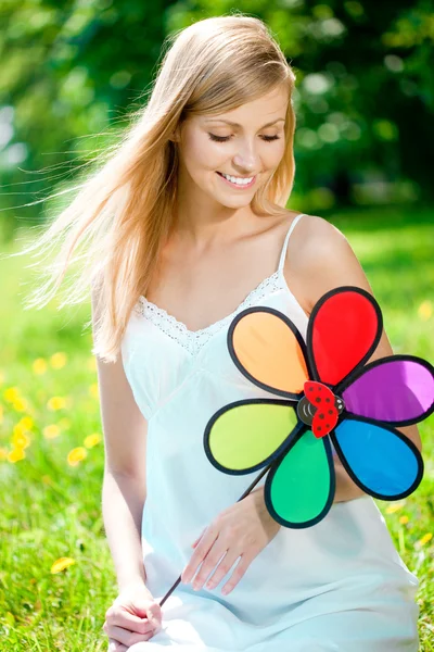 Mulher sorridente com uma flor de arco-íris ao ar livre Imagens De Bancos De Imagens Sem Royalties