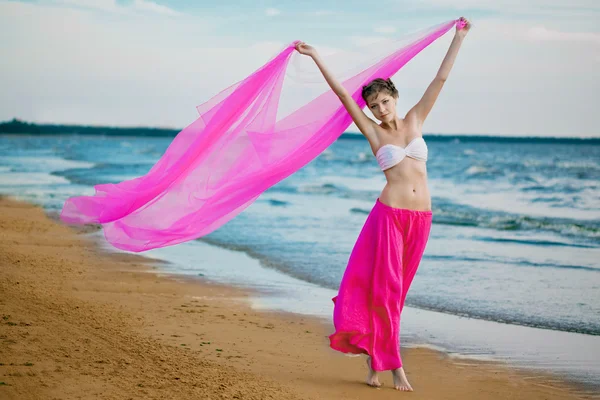 Donna con un fazzoletto in mano sulla spiaggia — Foto Stock