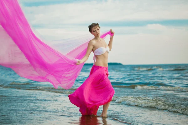 Frau mit einem Taschentuch in den Händen am Strand — Stockfoto