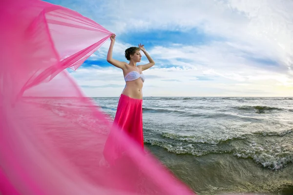 Kvinna med en vävnad i händerna på stranden — Stockfoto