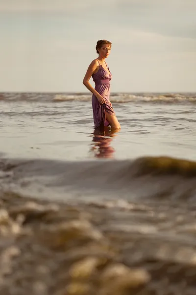 Donna sulla spiaggia al tramonto. — Foto Stock
